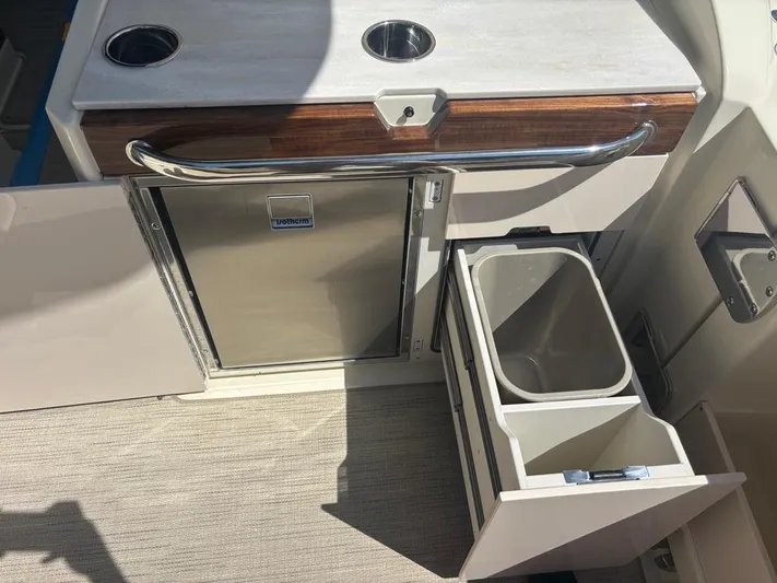  Yacht Photos Pics 2025 Chris-Craft Calypso 32 boat interior with stainless steel fridge and storage compartments.