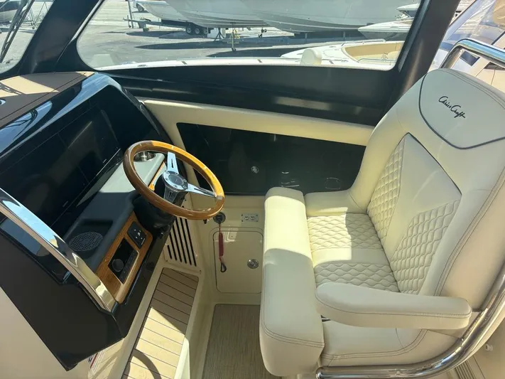  Yacht Photos Pics 2025 Chris-Craft Calypso 32 helm with luxurious seating and wooden steering wheel.