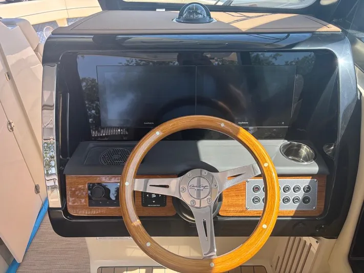  Yacht Photos Pics 2025 Chris-Craft Calypso 32 dashboard with wooden steering wheel and modern controls.