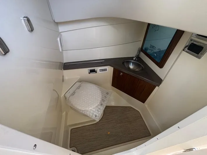  Yacht Photos Pics 2025 Chris-Craft Calypso 32 boat bathroom with sink, toilet, and mirror.