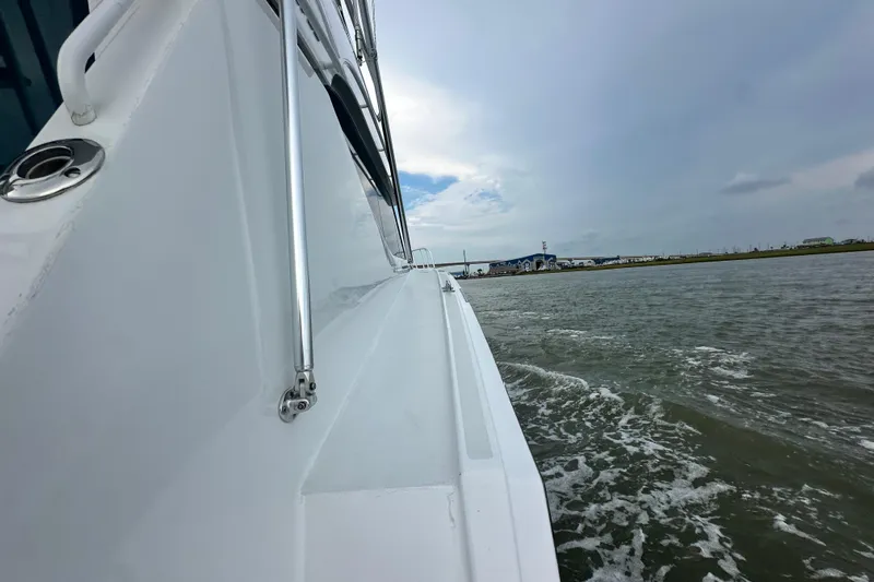 Loca Louise Yacht Photos Pics Side view of 2002 Hatteras 50 Convertible Sportfish cruising on water.