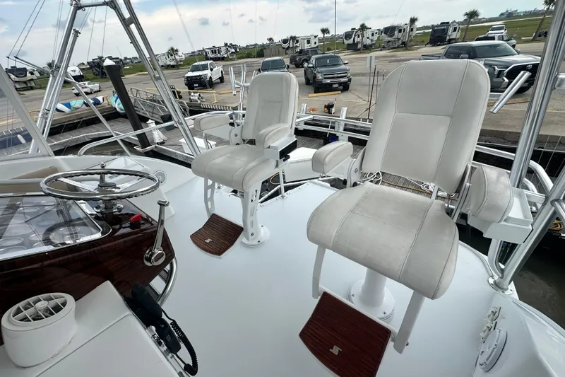 Loca Louise Yacht Photos Pics Helm of 2002 Hatteras 50 Convertible Sportfish with two white captain chairs.