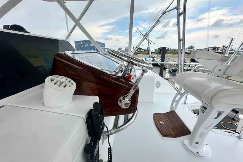 Loca Louise Yacht Photos Pics Helm of 2002 Hatteras 50 Convertible Sportfish with steering wheel and captain's chair.