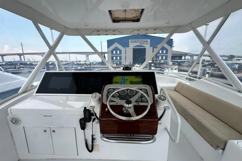 Loca Louise Yacht Photos Pics Helm of 2002 Hatteras 50 Convertible Sportfish at marina, featuring steering wheel and navigation equipment.