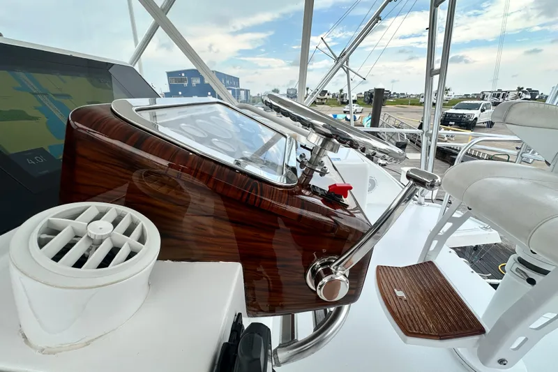 Loca Louise Yacht Photos Pics Helm of 2002 Hatteras 50 Convertible Sportfish with polished wood and modern controls.