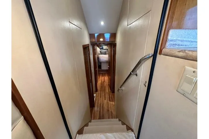 Loca Louise Yacht Photos Pics Interior hallway of 2002 Hatteras 50 Convertible Sportfish yacht with wooden flooring.