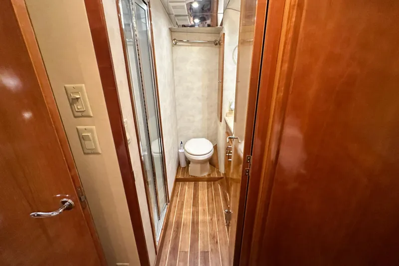 Loca Louise Yacht Photos Pics Bathroom interior of 2002 Hatteras 50 Convertible Sportfish yacht, featuring wood accents and modern fixtures.