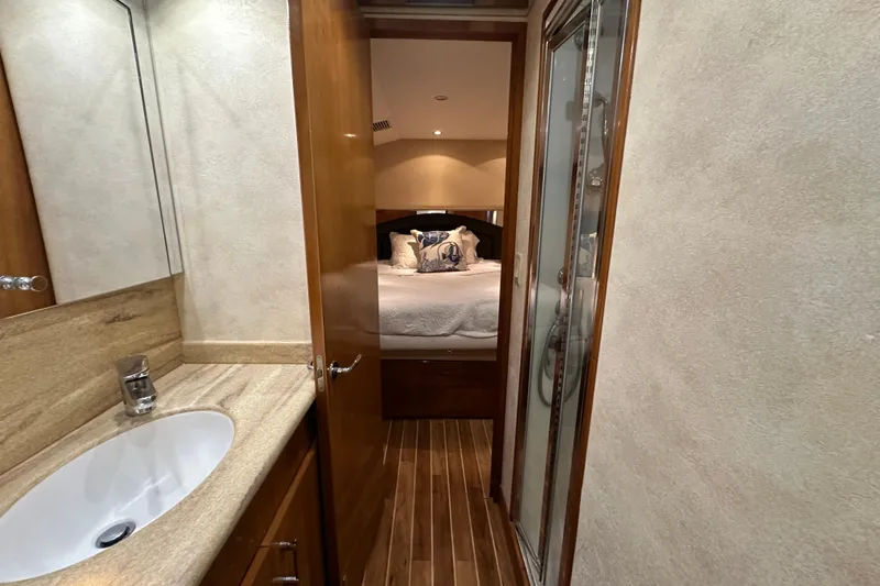 Loca Louise Yacht Photos Pics Interior of 2002 Hatteras 50 Convertible Sportfish, featuring a cozy bedroom and bathroom.