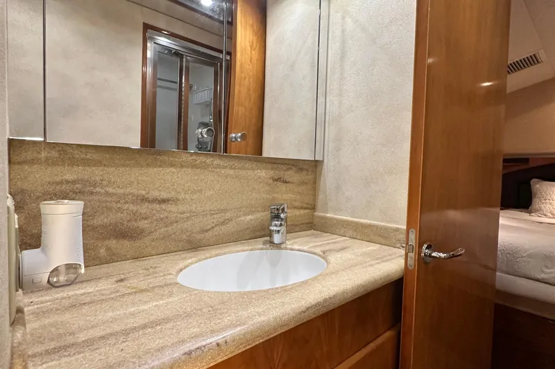 Loca Louise Yacht Photos Pics Bathroom interior of 2002 Hatteras 50 Convertible Sportfish yacht with modern sink and mirror.