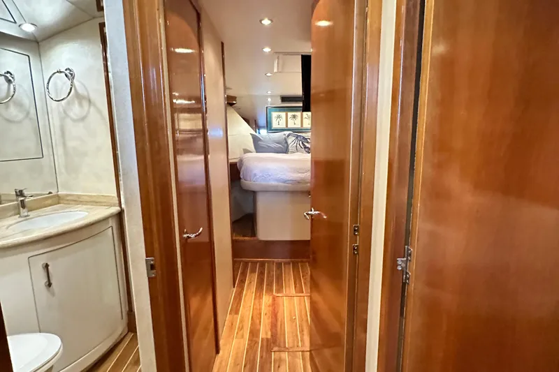 Loca Louise Yacht Photos Pics Interior of 2002 Hatteras 50 Convertible Sportfish, featuring wood paneling and a cozy bedroom.