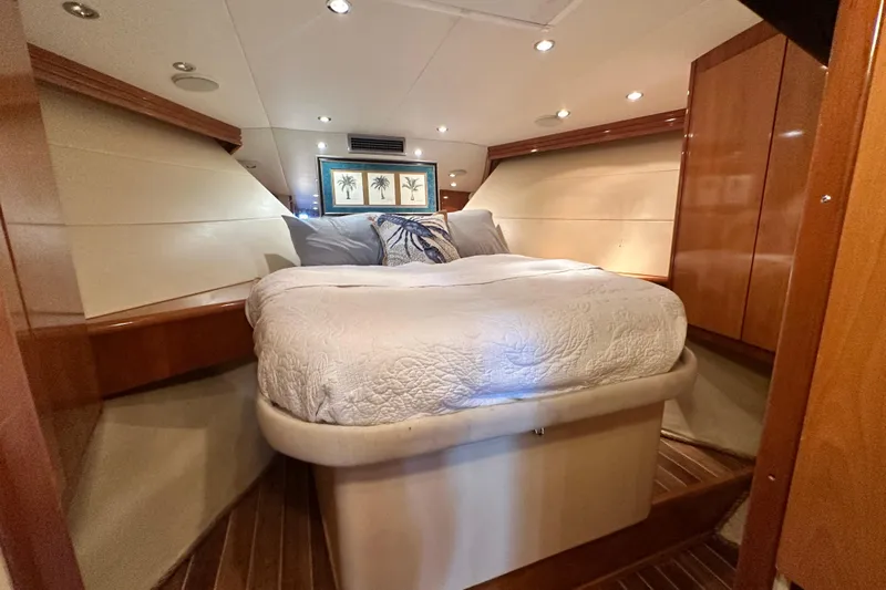 Loca Louise Yacht Photos Pics Luxurious bedroom interior of 2002 Hatteras 50 Convertible Sportfish yacht, featuring elegant wood finishes.