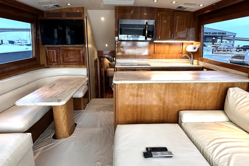 Loca Louise Yacht Photos Pics Luxurious interior of 2002 Hatteras 50 Convertible Sportfish yacht with modern kitchen and seating.