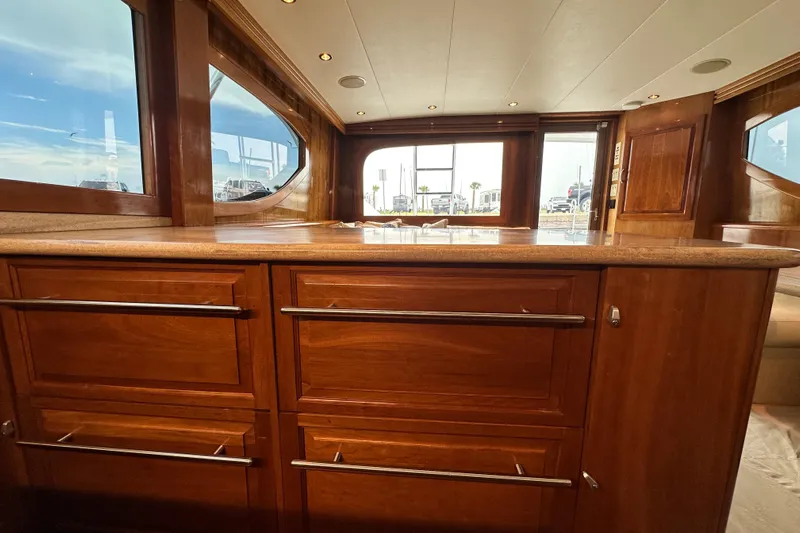 Loca Louise Yacht Photos Pics Luxurious interior of 2002 Hatteras 50 Convertible Sportfish with wooden cabinetry and large windows.