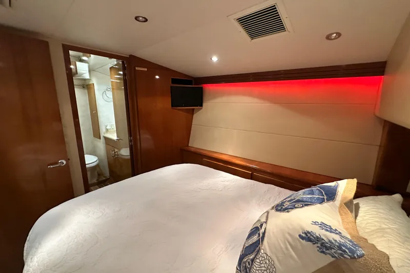Loca Louise Yacht Photos Pics Bedroom interior of 2002 Hatteras 50 Convertible Sportfish with ensuite bathroom and modern lighting.