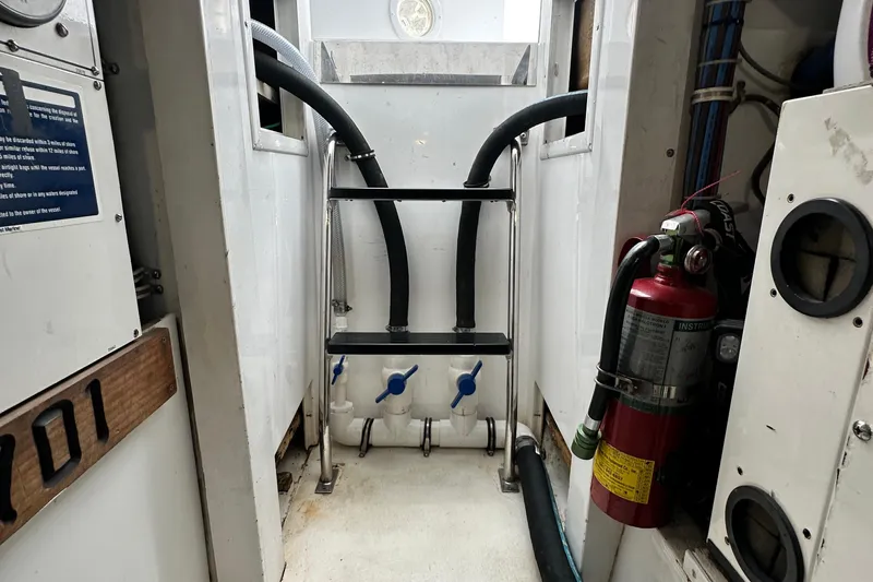Loca Louise Yacht Photos Pics Engine room of 2002 Hatteras 50 Convertible Sportfish with fire extinguisher and plumbing.