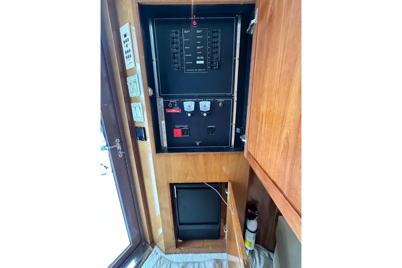 Loca Louise Yacht Photos Pics Electrical panel inside 2002 Hatteras 50 Convertible Sportfish boat, featuring control switches and fire extinguisher.