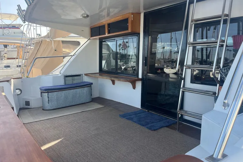  Yacht Photos Pics 1990 Mikelson 48 Sportfisher yacht deck with seating, ladder, and marina view.