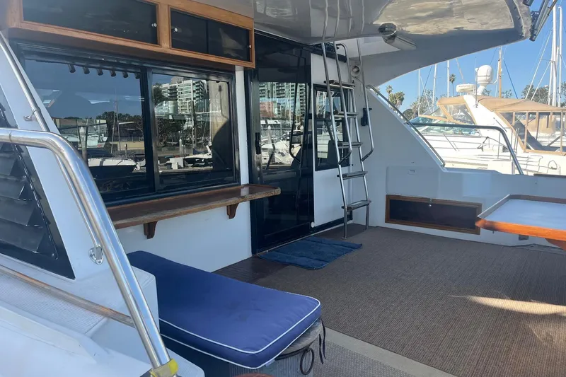  Yacht Photos Pics 1990 Mikelson 48 Sportfisher yacht deck with seating, ladder, and marina view.