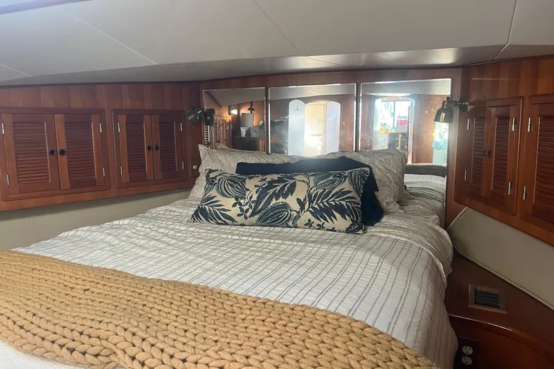  Yacht Photos Pics Cozy bedroom in 1990 Mikelson 48 Sportfisher yacht with wood cabinets and decorative pillows.