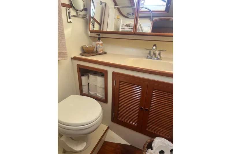  Yacht Photos Pics Bathroom interior of 1990 Mikelson 48 Sportfisher yacht with wooden cabinets and sink.