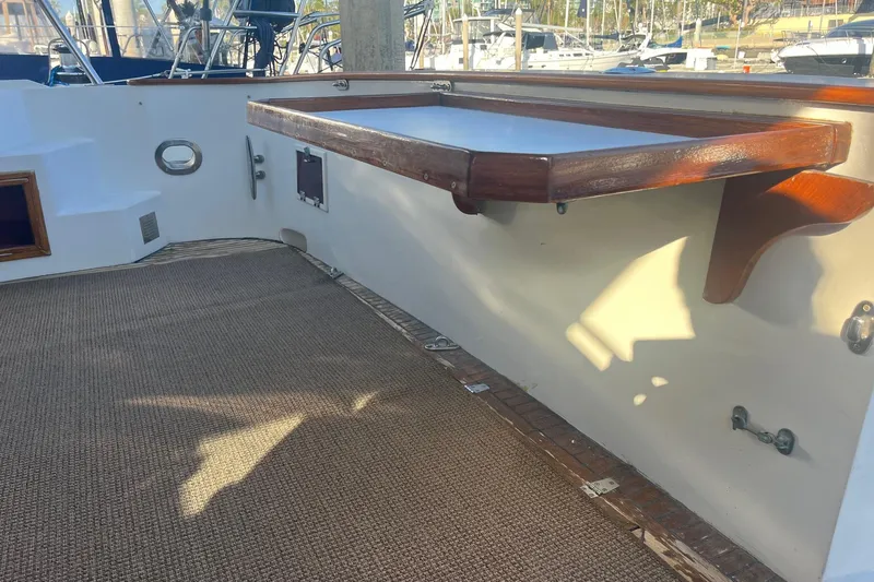  Yacht Photos Pics 1990 Mikelson 48 Sportfisher deck with wooden table and carpeted flooring.