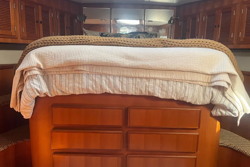  Yacht Photos Pics Cozy cabin interior of 1990 Mikelson 48 Sportfisher with wooden cabinetry and neatly made bed.