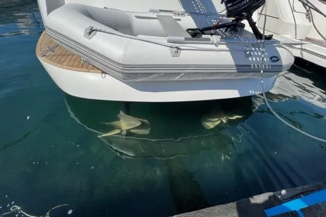  Yacht Photos Pics 2011 Pershing 50.1 yacht with inflatable boat, docked in clear water.