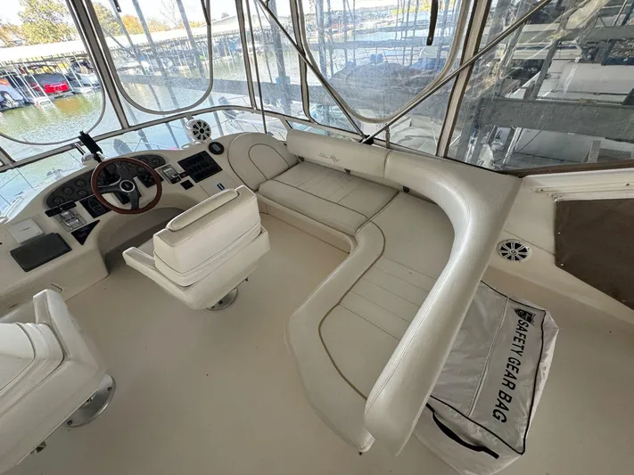  Yacht Photos Pics 1996 Sea Ray 400 Sedan Bridge interior with white seating and safety gear bag.