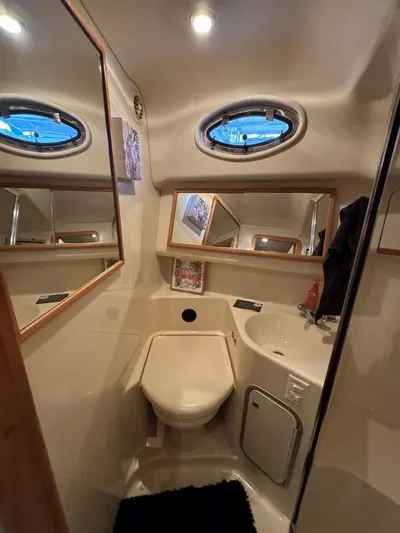  Yacht Photos Pics Bathroom interior of 1996 Sea Ray 400 Sedan Bridge yacht, featuring compact design and porthole window.