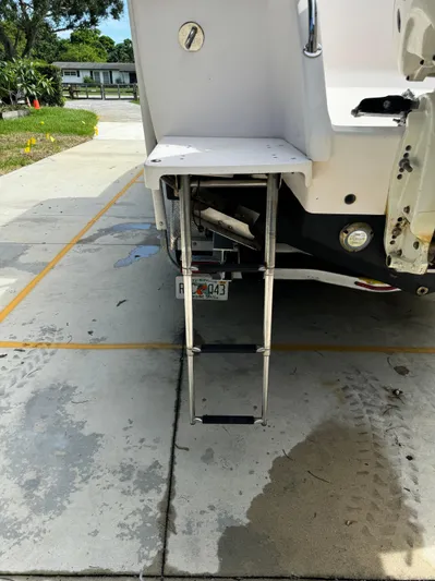  Yacht Photos Pics 2001 Intrepid 327 Center Console boat with extended swim ladder on a concrete driveway.