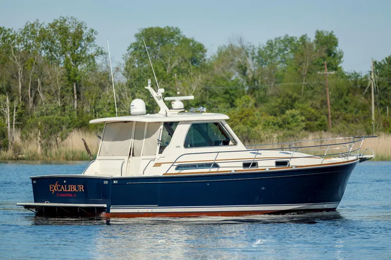  Yacht Photos Pics 2009 Sabre 42 Express boat on calm water with lush green background.