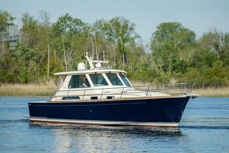 Yacht Photos Pics 2009 Sabre 42 Express yacht cruising on a calm lake with trees in the background.