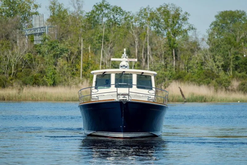  Yacht Photos Pics 2009 Sabre 42 Express boat on calm water with lush green background.