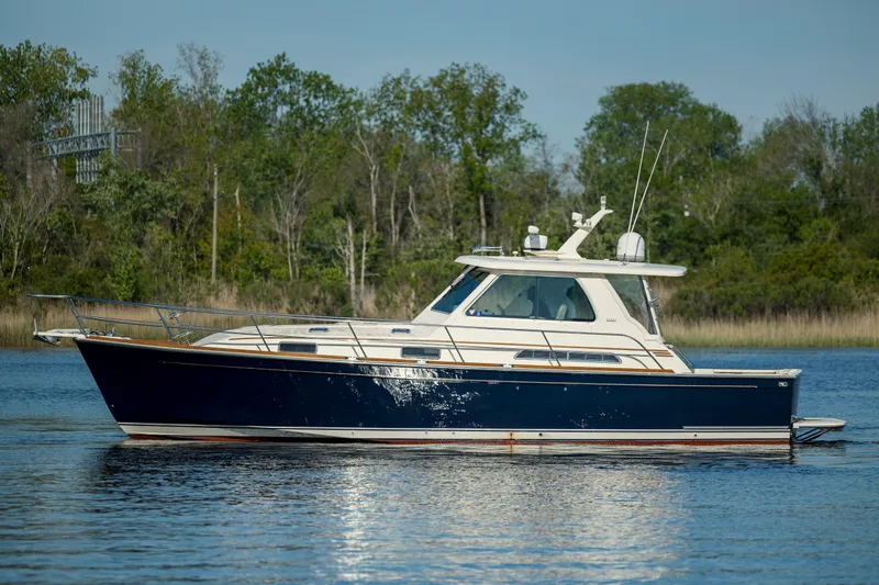  Yacht Photos Pics 2009 Sabre 42 Express yacht on calm water with trees in the background.