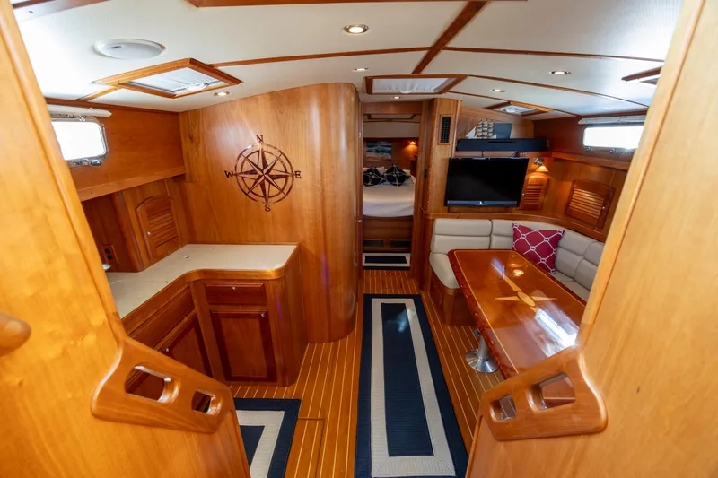  Yacht Photos Pics 2009 Sabre 42 Express yacht interior with wood finish, dining area, and compass wall design.