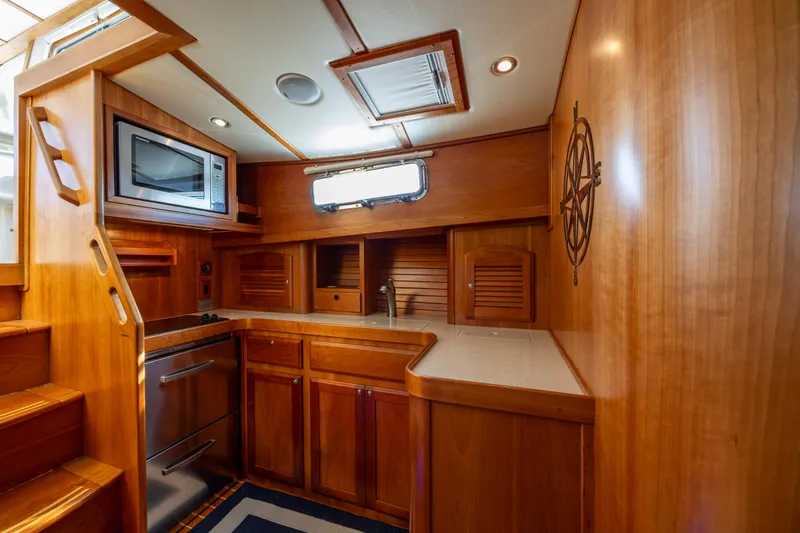  Yacht Photos Pics 2009 Sabre 42 Express yacht interior kitchen with wood cabinetry and modern appliances.