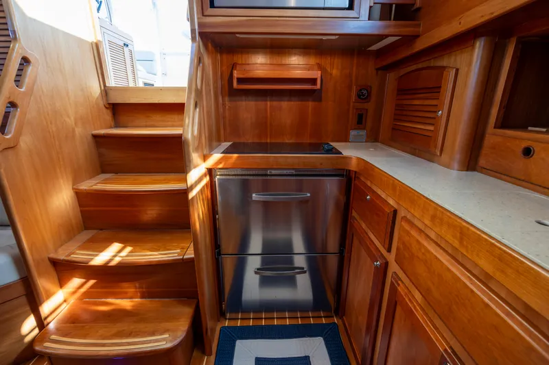  Yacht Photos Pics 2009 Sabre 42 Express yacht interior with wooden cabinetry and compact kitchen area.