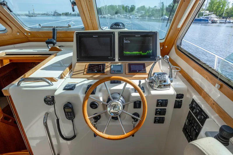  Yacht Photos Pics Helm of 2009 Sabre 42 Express yacht with navigation screens and wooden steering wheel.