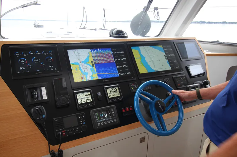 Build To Order Yacht Photos Pics Control panel of 2026 Chris White Spindrift 47 yacht with navigation screens and steering wheel.