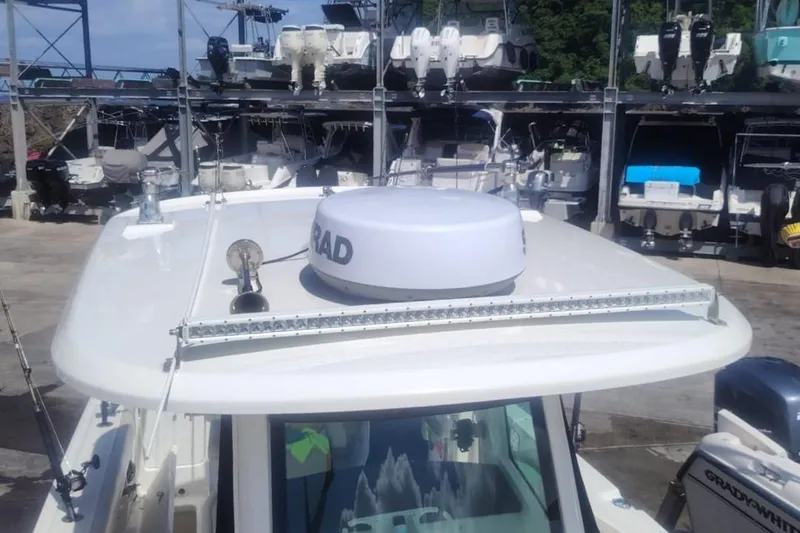  Yacht Photos Pics 2024 Boston Whaler 280 Outrage boat with radar and equipment, docked in a marina.