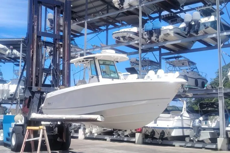  Yacht Photos Pics 2024 Boston Whaler 280 Outrage boat on forklift in marina storage facility.