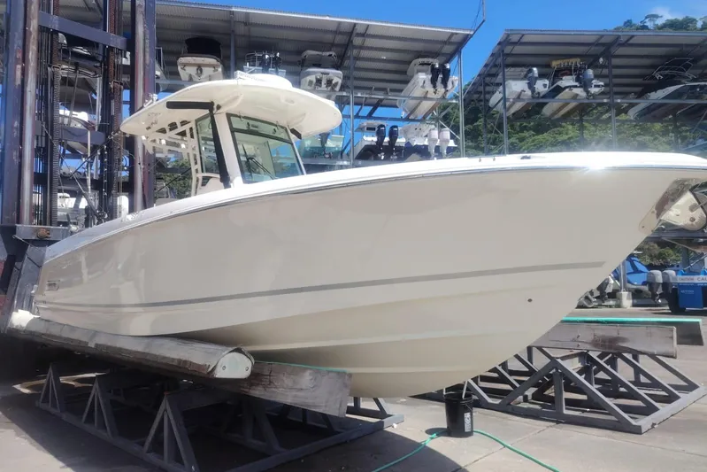  Yacht Photos Pics 2024 Boston Whaler 280 Outrage boat on dry dock, showcasing sleek design and modern features.