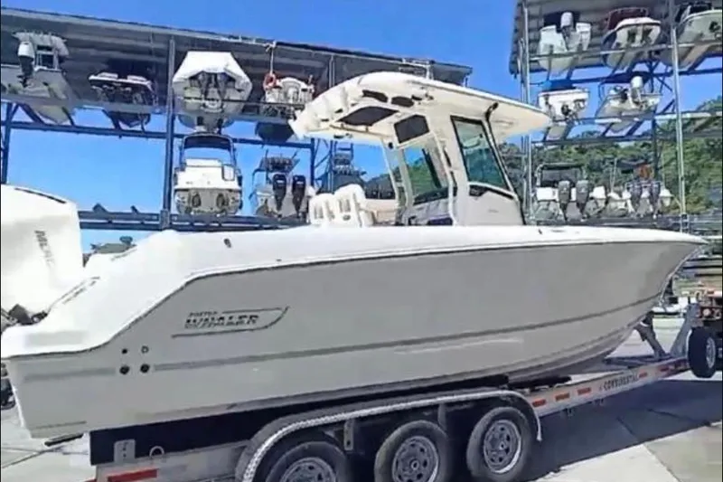  Yacht Photos Pics 2024 Boston Whaler 280 Outrage on trailer, surrounded by stacked boats in marina.