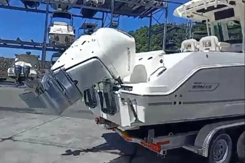  Yacht Photos Pics 2024 Boston Whaler 280 Outrage boat on trailer, featuring powerful engines, in a marina setting.