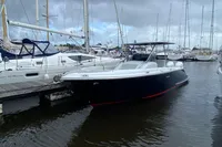2021 Comitti Isola 33 boat docked in a marina, surrounded by sailboats.