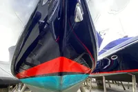 2021 Comitti Isola 33 boat with sleek black hull and vibrant red stripe.