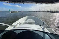 Bow view of 2021 Comitti Isola 33 boat on a sunny day, with marina in background.