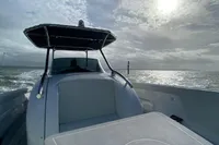 2021 Comitti Isola 33 boat cruising under a cloudy sky with sun.