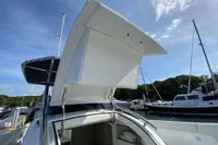2021 Comitti Isola 33 yacht with open hatch, docked under a clear blue sky.