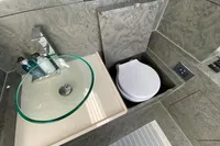 Modern bathroom in 2021 Comitti Isola 33 with glass sink and compact toilet.